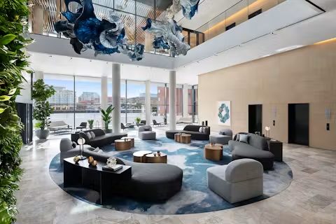 Sảnh sự kiện trần cao với sofa tròn và tác phẩm thuỷ tinh